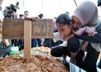 NOR Izzati Syamimi Suhaimi, 31, memeluk anaknya, Adelia Sofia Zainol Afiq, 6, selepas pengebumian suaminya, Allahyarham Kapten Zainol Afiq Bee Sham di Tanah Perkuburan Islam Forest Height, Senawang, Seremban, petang tadi. - UTUSAN/MOHD. SHAHJEHAN MAAMIN