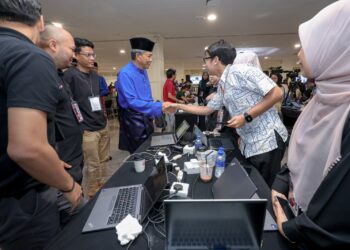 MOHAMAD Hasan bersalaman dengan wartawan Utusan Malaysia ketika melawat Laman Media sempena Perhimpunan Agung UMNO (PAU) 2026 hari ini. UTUSAN/FARIZ RUSADIO