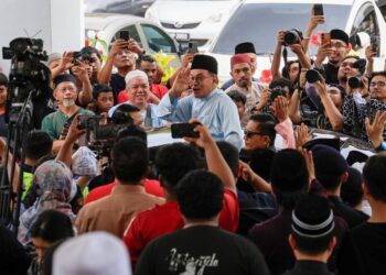 ANWAR Ibrahim melambai ke arah jemaah ketika beredar selepas menunaikan solat Jumaat di Masjid Bukit Indah, Ampang.