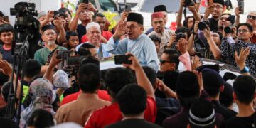 ANWAR Ibrahim melambai ke arah jemaah ketika beredar selepas menunaikan solat Jumaat di Masjid Bukit Indah, Ampang.