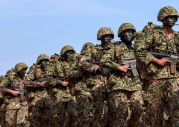 KUALA TERENGGANU 31 Ogos 2026 - Kontinjen-kontinjen dari pelbagai agensi mengambil bahagian dalam perbarisan sambutan Hari Kebangsaan Ke-69 peringkat Terengganu di Dataran Syahbandar Kuala Terengganu, hari ini. Kira-kira 10,000 pengunjung beratur di sepanjang jalan sejak awal pagi bagi menyaksikan perarakan merdeka yang disertai 3,500 peserta dari 119 kontinjen termasuk jabatan persekutuan dan negeri, syarikat berkaitan kerajaan, badan bukan kerajaan, syarikat swasta, sekolah menengah dan badan berkanun dari seluruh Terengganu.- UTUSAN/PUQTRA HAIRRY *** Local Caption *** Perspektif sudut rendah menonjolkan disiplin dan perpaduan tentera. Tokoh utama mendominasi latar depan, manakala barisan menyusut ke kejauhan, mewujudkan kedalaman dan pergerakan. Langit cerah mengontraskan formasi, sekali gus menegaskan tema kekuatan dan kerja berpasukan.