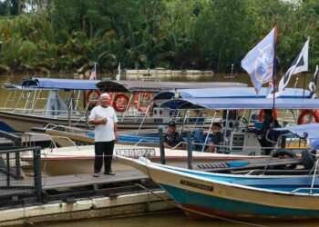 RAMLI Man bergambar dengan sebahagian 11 bot yang dimilikinya untuk membawa pelancong menyusuri Sungai Terengganu ketika ditemui di Kuala Terengganu, Terengganu. – UTUSAN/PUQTRA HAIRRY