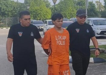 TERTUDUH semasa dibawa anggota polis untuk menghadiri prosiding perbicaraan di Mahkamah Sesyen Kota Bharu, Kelantan hari ini-UTUSAN/YATIMIN ABDULLAH.