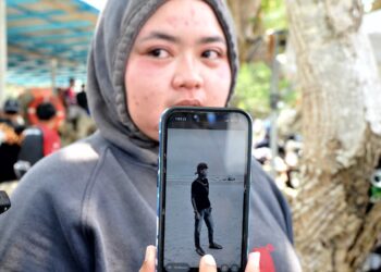 NUR Adriana Dania menunjukkan gambar adiknya, Muhammad Thaqif Rayyan yang merupakan salah seorang daripada empat mangsa lemas di Pantai Tanjung Lompat, Desaru, Kota Tinggi.
