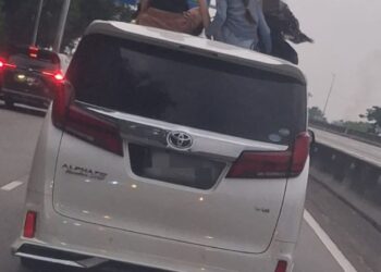 TANGKAP layar beberapa kanak-kanak mengeluarkan sebahagian badan melalui bumbung kenderaan yang sedang bergerak.