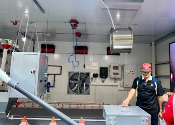 SEORANG petugas menunjukkan teknologi sistem kawalan iklim yang membolehkan reban dipantau dan dikawal menerusi telefon pintar.