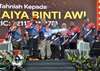 Ahmad Zahid Hamidi dan Ab. Rauf Yusoh menyampaikan replika kunci motosikal Yamaha RXZ kepada Suraiya Awai dalam cabutan bertuah pada penutupan Karnival Anak Muda Melaka Jom Heboh 2026 di Pusat Dagangan Antarabangsa Melaka (MITC) hari ini. UTUSAN/AMRAN MULUP
