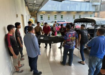HILMI Abdullah (kiri) menanti jenazah mangsa tiba di Unit Forensik Hospital Sultan Ismail Petra, Kuala Krai, Kelantan untuk bedah siasat sebelum diserahkan kepada keluarga bagi urusan pengebumian.