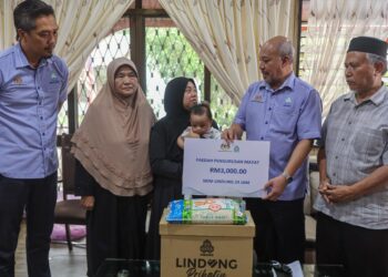 Balu Allahyarham Amirul Fahmi Wan Jusoh iaitu Nur Izzah Ahmad (tengah) menerima Pencen Faedah Orang Tanggungan yang disampaikan oleh Hisham Abdul Rahman (dua dari kanan) di rumah keluarganya di Kampung Paloh Sungai Kiat, Kuala Terengganu, Terengganu.