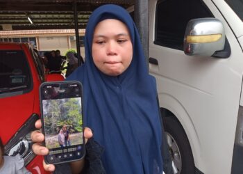 NUR ELLYSYA Alias menunjukkan gambar pasangan suami isteri, Mohd. Herwan Alias dan Nur Ezazaya Mohd. Ali yang maut dalam kemalangan di Kilometer 31.2, Jalan Kota Tinggi–Kluang, Kota Tinggi.