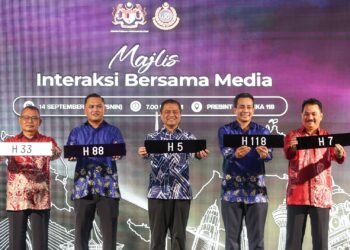 AEDY Fadly Ramli (tengah) menujukkan  nombor pendaftaran baru sempena Hari Malaysia pada Majlis Interaksi Bersama Media Sempena Hari Malaysia di Presint Merdeka 118.