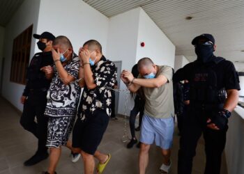 ANGGOTA polis mengawal empat tertuduh warga China yang dihadapkan ke mahkamah atas pertuduhan menculik di Mahkamah Sesyen Alor Setar, hari ini. - UTUSAN/ SHAHIR NOORDIN