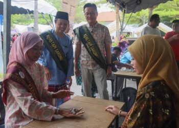 YEOH Soon Hin (berdiri kanan) melihat pengunjung bermain permainan tradisional, Batu Seremban pada program Keretapi Sarong 2026 yang berlangsung di Muzium Feri Pulau Pinang, hari ini.-UTUSAN/DANIAL SAAD