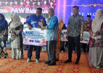 AB. Rauf Yusoh menyampaikan anugerah kepada seorang penerima sempena Majlis Perasmian Sambutan Hari Warga Emas, Hari OKU dan Hari Kanak-kanak Peringkat Negeri di Alor Gajah, Melaka hari ini. - UTUSAN/AMRAN MULUP