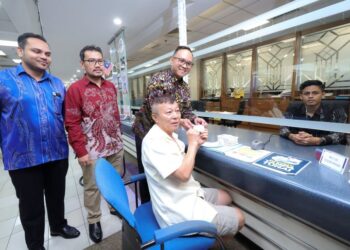 MUHAMMAD Asraf Sukadi (tiga dari kiri) menyerahkan MyKad generasi baharu kepada orang awam pada hari pertama penukaran MyKad generasi baharu ketika tinjauan di Ibu Pejabat Jabatan Pendaftaran Negara (JPN) Putrajaya, hari ini. - UTUSAN/FAISOL MUSTAFA