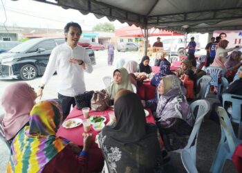 MUHAMMAD Kamil Abdul Munim menyantuni penduduk yang hadir ke majlis minum petang di Padang Rengas, Perak hari ini.-UTUSAN/FADZIL ZAINOL