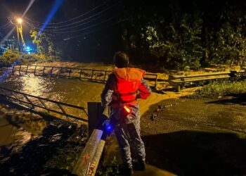 ANGGOTA APM Gua Musang, Kelantan memantau keadaan paras air selepas beberapa kawasan di jajahan ini ditenggelami air malam tadi.-IHSAN APM GUA MUSANG