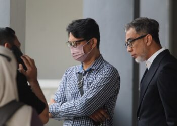 TERTUDUH (tengah) semasa menghadiri prosiding perbicaraan di Mahkamah Sesyen Kota Bharu, Kelantan hari ini-UTUSAN/KAMARUL BISMI KAMARUZAMAN.