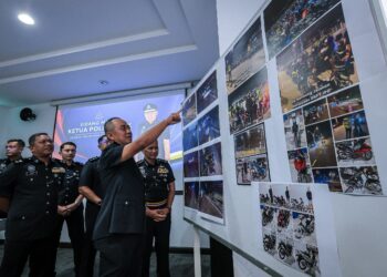 MOHD. Alwi menunjukkan gambar-gambar kemalangan maut di Jalan Jelapang-Ampang di Ipoh ketika sidang akhbar di IPD Muallim di Slim River hari ini.