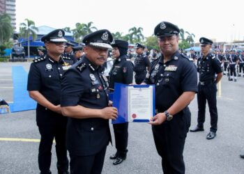 MOHD. Yusoff Mamat (kiri) menyerahkan surat penghargaan kepada anggota selepas merasmikan Perhimpunan Bulanan Ibu Pejabat Polis Kontinjen (IPK) Kelantan, Kota Bharu, Kelantan hari ini-UTUSAN/KAMARUL BISMI KAMARUZAMAN.