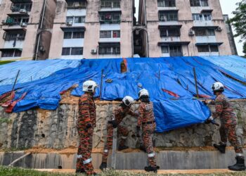 Anggota bomba ketika menutupi kawasan tanah runtuh dengan kanvas pada tinjauan di Flat Bandar Damai Perdana, Bandar Tun Hussein Onn di sini, hari ini. - UTUSAN/SYAKIR RADIN