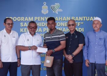 RASHIDI Zinol (dua dari kiri) ketika menyampaikan sumbangan kepada seorang penerima pada Program Penyerahan Bantuan Sara Hidup Kepada Pesawah Padi dan Petani Sayur di PPK Sungai Acheh, Nibong Tebal, Pulau Pinang hari ini.-UTUSAN/DANIAL SAAD