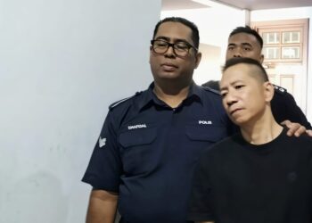 NG Peng Kim (kanan) diiringi oleh anggota polis ketika dihadapkan ke Mahkamah Sesyen George Town, Pulau Pinang atas pertuduhan cuba merompak sebuah kedai jam, minggu lepas.-UTUSAN/SAFINA RAMLI