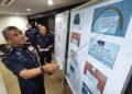 ALZAFNY Ahmad menunjukkan beberapa gambar berkaitan gambar semasa sidang akhbar di IPK Negeri Sembilan di Seremban hari ini.-UTUSAN/MOHD. SHAHJEHAN MAAMIN