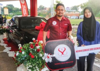 Rabiatul Adawiyah menerima kunci kereta BMW yang dimenanginya daripada Pengerusi Kedai Emas Sri Semantan (KESS), Mohd. Hafizal Mahmood, di Bandar Tun Abdul Razak Jengka, baru-baru ini.