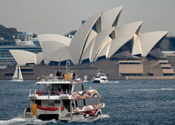 SEBUAH bot membawa pelancong di Sydney Harbour. - AFP
