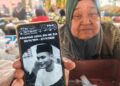 JAMALIAH Abdullah menunjukkan gambar Allahyarham Nik Muhamad Adha Nik Zulkifli ketika ditemui di Pasar Tani Kekal Changlun, Kubang Pasu.