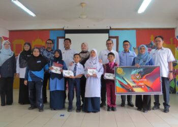 FADHLINA Sidek (tengah) menyampaikan kelengkapan sekolah kepada murid ketika hadir ke Program Tindak Susul Parlimen Siri 3 di Sekolah Kebangsaan Gua Musang, Gua Musang, Kelantan.