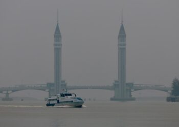 SEBUAT bot melintasi Jambatan Angkat Kuala Terengganu berlatarbelakangkan keadaan udara berjerebu semasa tinjauan di Kuala Terengganu, Terengganu. - UTUSAN/PUQTRA HAIRRY