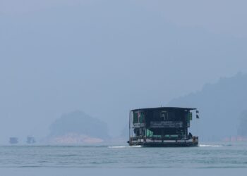 RUMAH bot membawa pelancong berlatar belakangkan keadaan udara berjerebu semasa tinjauan di Pengkalan Gawi, Tasik Kenyir, Hulu Terengganu, Terengganu. - UTUSAN/PUQTRA HAIRRY