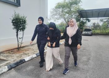 NUR Amnie Nadirah Mat Din (tengah) diiring keluar dari Mahkamah Majistret Besut, Terengganu. - UTUSAN /WAN ZURATIKAH IFFAH WAN ZULKIFLI