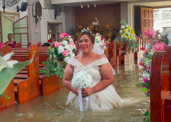 LEIN Lieza Galang meredah banjir pada majlis perkahwinannya. - AFP