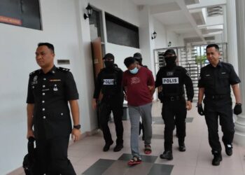 G. Vikneswaran dikawal anggota polis selepas didakwa membunuh isterinya di Mahkamah Majistret Kulim, hari ini.