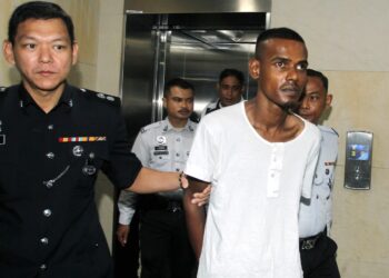 K. VIKNES (kanan) dibawa ke Mahkamah Sesyen Ipoh hari ini bagi menghadapi pertuduhan cubaan membunuh seorang anggota polis trafik, minggu lalu. - UTUSAN