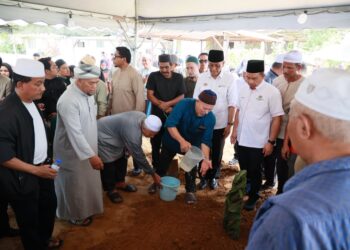 KAMARUDIN Salleh (empat kiri) menyiramkan air ke pusara Dr. Ainul Baraah di Tanah Perkuburan Islam Sri Kedeper, Baung, Pengkalan Chepa, Kota Bharu, Kelantan. - - UTUSAN/KAMARUL BISMI KAMARUZAMAN