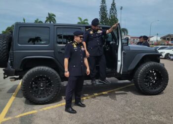 MUHAMMAD Kifli Ma Hassan (kanan) memeriksa salah sebuah kenderaan mewah yang disita dalam Op Luxury di Ibu Pejabat Jabatan Pengangkutan Jalan (JPJ) Kelantan, Panji, Kota Bharu, Kelantan. - UTUSAN/MUSTAQIM MOHAMED