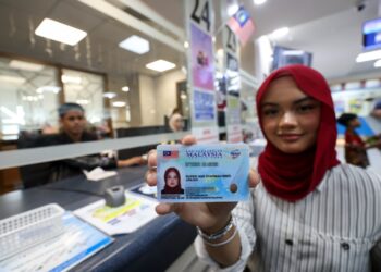 Puteri Nur Syafiqah Jailani menunjukkan MyKad generasi baharu yang diperolehnya di Ibu Pejabat JPN Putrajaya, semalam. – UTUSAN/FAISOL MUSTAFA