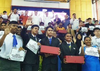 NGA Kor Ming (belakang, tengah) bergambar dengan pelajar yang menyertai Program Anak Angkat Menteri KPKT di Teluk Intan, Perak hari ini. - UTUSAN/FADZIL ZAINOL