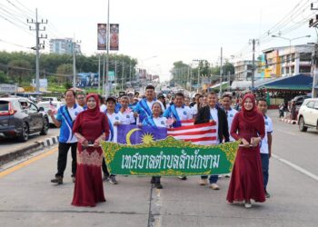MASYARAKAT Thailand yang menyertai perarakan sempena sambutan Hari Kebangsaan Malaysia ke-69 sambil membawa Jalur Gemilang di Dannok, Thailand. – IHSAN MEDIA SOSIAL