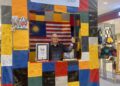 Alfred menunjukkan sijil dan pengiktirafan MBOR menerusi kejayaan 'Beg Tarpaulin Upcycle Terbesar' di Bukit Jalil.