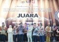 abdul Karim Rahman Hamzah menyampaikan hadiah kepada juara Sayembara  Deklamasi Puisi Kemerdekaan (SPDK) 2026, Khalid Husseini Tuah di Kuching baru-baru ini.
