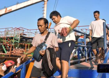 MANGSA yang terselamat turun dari sebuah feri selepas diselamatkan di pelabuhan Banjarmasin, Kalimantan Selatan. - AFP