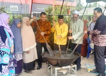 AHMAD Fahmi Ahmad Sarkawi (kanan) mengacau bubur asyura pada pada program ramah mesra bersama pelajar Sekolah Agama Islam Sirithamwittaya (Pondok Duku), Kampung Duku, Daerah Bacho, Narathiwat, Thailand. - UTUSAN/ RAZALI ZAKARIA