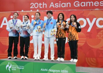 Ong Ker Ying-Lee Yiat Qing (kanan) pada upacara penyampaian pingat dala acara 3 meter papan anjal di Sukan Asia Aichi-Nagoya 2026, semalam. - AFP