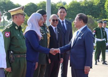 Min Aung Hlaing (kanan, depan), bersalaman dengan pegawai di Lapangan Terbang Antarabangsa Naypyidaw sebelum berlepas ke Malaysia bagi lawatan rasmi selama dua hari.-AFP