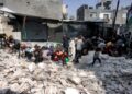 PENDUDUK berlindung daripada serangan dron ketika beratur mendapatkan makanan daripada dapur amal di kem pelarian Palestin Jabalia, utara Semenanjung Gaza.-AFP